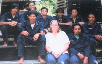 image009 Photographic Memories: Pak Ateng (top row, far right with a yellow shirt showing under his uniform) back when he first started working at the OFI Care Center. (Western visitor is in center).
