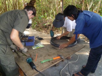 image001 Staff and volunteer cutting tires for hammocks and other projects
